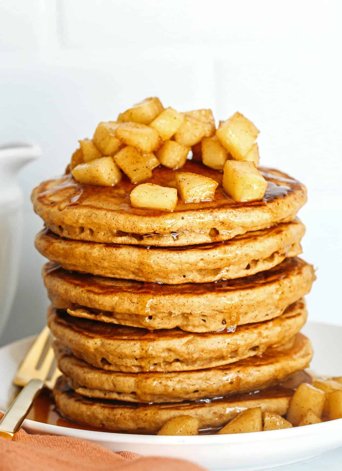 Light and fluffy Apple Cinnamon Pancakes made healthier with whole wheat flour, applesauce in place of oil and zero butter or refined sugar! Topped with warm spiced apples and drizzled with maple syrup!